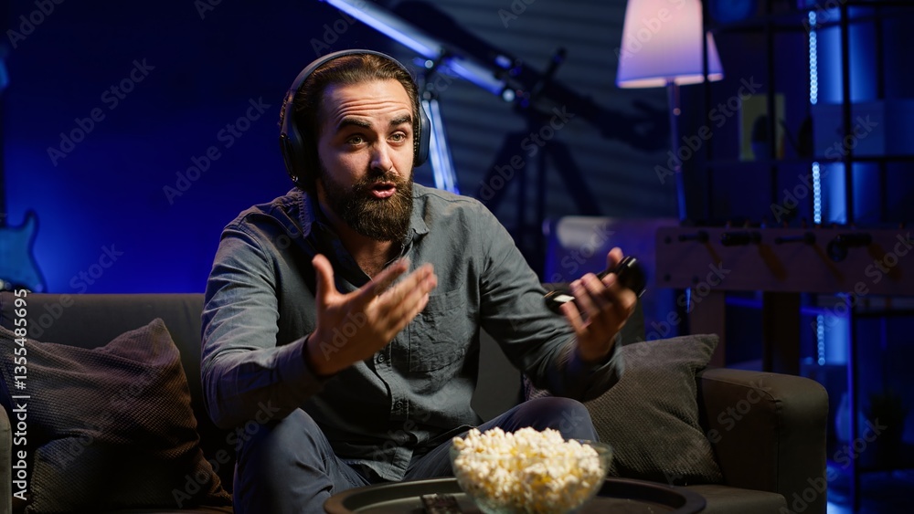 Poster man looking in disbelief at tv screen while playing videogames, receiving game over message on gamin