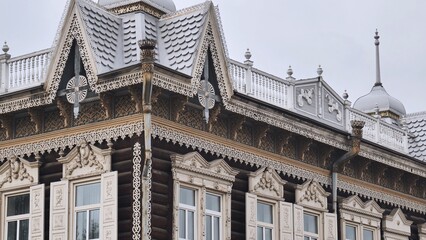 Fototapeta premium Traditional russian architecture showcasing intricate carvings, decorative metal roofing, and ornate window frames in a detailed exterior view