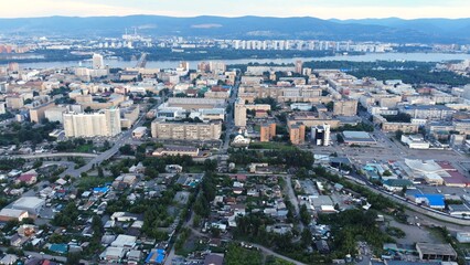 Krasnoyarsk urban landscape viewed from above, revealing residential zones, commercial structures near yenisei river and kommunalny bridge