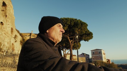 Retired Man Looks At The Landscape During A Tourist Visit To An Italian Old Town