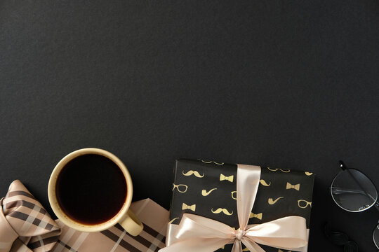 Stylish gift box, coffee cup, glasses, necktie, and ribboned box on a black background. Perfect for Father's Day, birthdays, or sophisticated men's gifting themes - Powered by Adobe