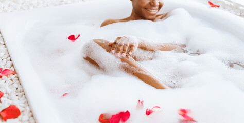 Beauty care, spa treatments and relax at home. Cheerful young african american female in bathtub...