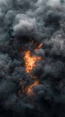 Intense orange fire surrounded by thick swirling dark smoke clouds