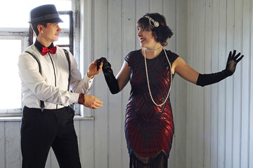 Ein Paar im 20er Jahre Retro Style tanzen vor einem Fenster