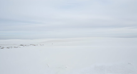 Obraz premium Walking Across White Sand Dunes Under Overcast Sky Landscape