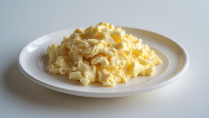 Homemade tasty scrambled eggs on a white plate, white background medium shot