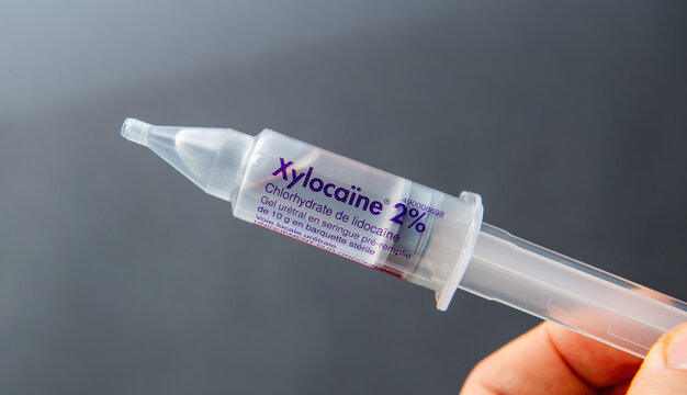 Paris, France - Mar 10, 2025: A hand holds a Xylocaine 2 percent sterile prefilled syringe containing lidocaine gel for local urethral use, with clear labeling visible against a soft grey background
