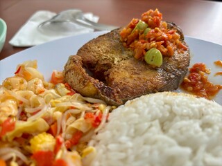 Indonesian dish with white rice, fried tuna topped with spicy sambal petai, served with stir-fried bean sprouts. A flavorful and traditional meal