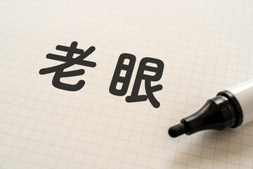 老眼と書かれたノートとマーカー