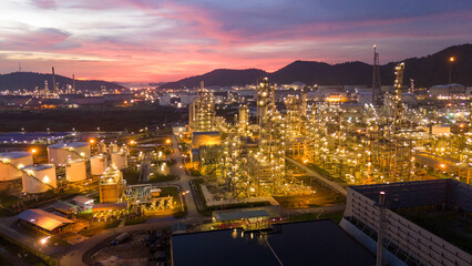 Fototapeta premium Oil Refinery plant at sunset. Gas Chemical Equipment Prodiction import export Concept, Crude Oil Refinery Plant Steel Pump Pipe line and Chimney and Cooling tower, Chemical Petrochemical