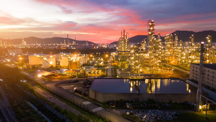 Obraz premium Oil Refinery plant at sunset. Gas Chemical Equipment Prodiction import export Concept, Crude Oil Refinery Plant Steel Pump Pipe line and Chimney and Cooling tower, Chemical Petrochemical
