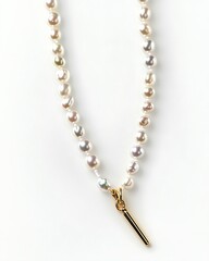 A gold colored necklace with a white bead and a silver colored stick