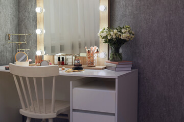 Makeup room. Mirror, dressing table, different beauty products and chair indoors