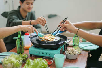 Group of Friends Cooking Slice Beef Together During Barbeque Party