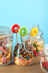 Fototapeta premium Candy bar. Many different sweets on wooden table against light blue background, closeup