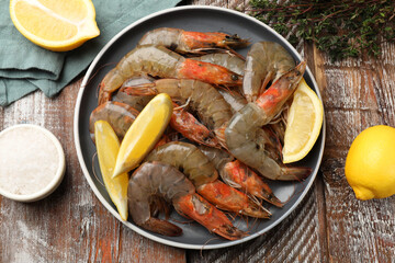 Fresh raw shrimps and spices on wooden table, flat lay