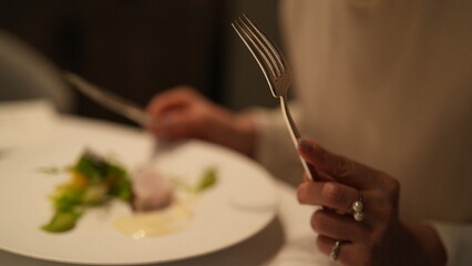 食事中の女性とカトラリー