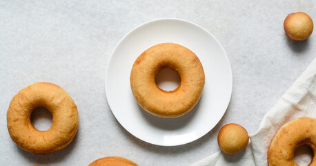 Overhead view of fresh donuts on a white background, top view of homemade doughnuts, process of making doughnuts