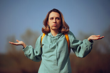 
Confused Woman Wearing a Backpack Shrugging in Nature 
Unsure lady feeling puzzled and lost...