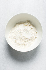 overhead view of All purpose flour in a bowl, top view of baking flour in a ceramic bowl