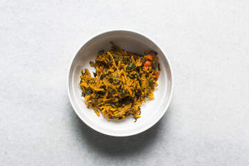 Overhead view of abacha or african salad in a white bowl, top view of cassava salad, nigerian african salad with onions and ugwu leaf	