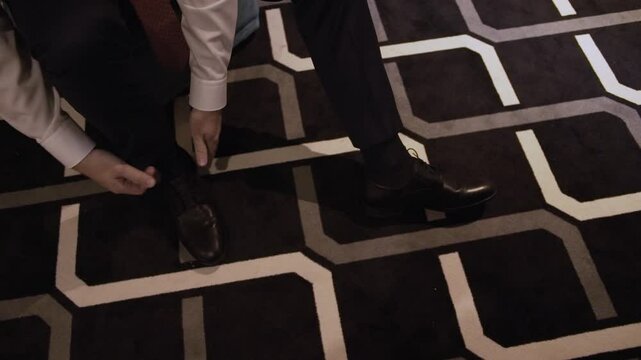 Male businessman a visit and tie black shoes in black trousers