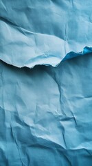 Naklejka premium Textured, blue paper with crumpled and torn details evokes a sense of fragility and artistic design.