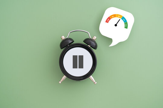 Black alarm clock with pause sign and battery charge indicator on real white speech bubble paper cut, for take a break, relaxation, overworked concept, hormone replacement therapy