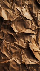 Naklejka premium Textured surface of crumpled brown kraft paper forming interesting folds and shadows on a flat background.