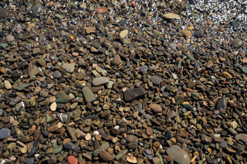 Sea pebbles on the Black Sea coast of the Krasnodar Territory resort on a sunny day, Sochi, Krasnodar Krai, Russia