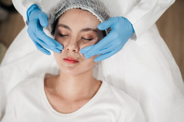 Fototapeta premium Close up, Asian woman receives facial treatment at beauty clinic, Beautician cleans her face in preparation for beauty injections.