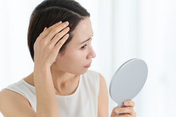 ヘアケアをする若い女性　ビューティーイメージ