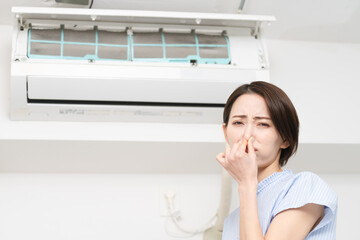 エアコンの匂いが気になる若い女性　ライフスタイルイメージ