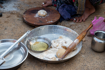 A village woman makes bread on the stove. cooking bread in clay stove , chula , makeing bread , roti , in village