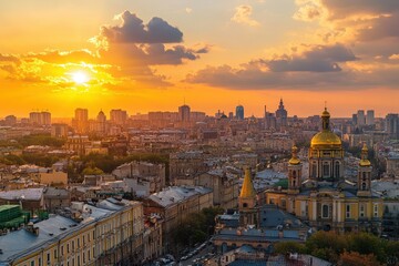 Obraz premium Cityscape sunset over architecture European city with domes & buildings against golden sky