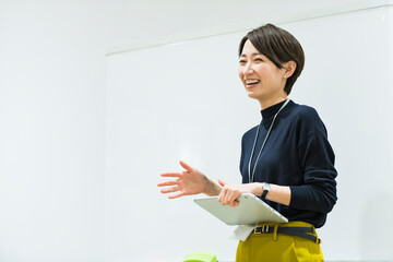 会議室でプレゼンをする30代日本人女性