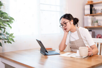 Young in apron woman working remotely from home