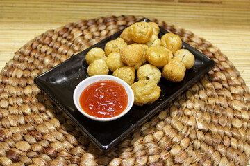 a plate of fried meatballs with sauce. snack for casual events