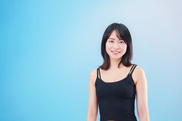 Obraz premium スポーツをする若い女性（水色背景）