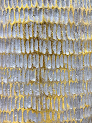 Close up of random embossed wall pattern sprayed with gold metallic paint. Suitable for clay pottery. Gold and grunge cement color, seamless background texture.