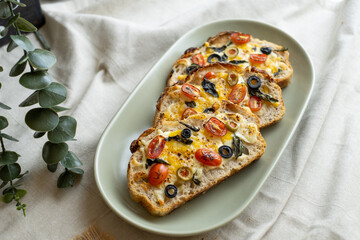 open sandwiches sourdough bread toast for breakfast or brunch with cheese tomato olives.