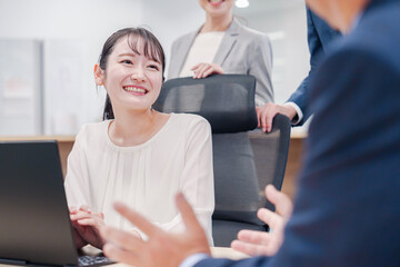 笑顔で上司の話を聞く若いビジネスウーマン