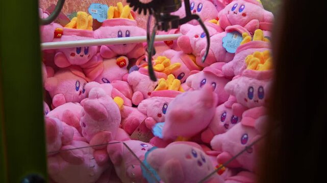 Playing the claw machine to catch plush toys, close up shot.