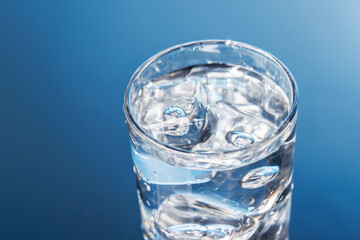 A clear glass filled with chilled water and ice cubes, creating a refreshing and cool drink