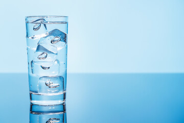 A clear glass filled with chilled water and ice cubes, creating a refreshing and cool drink