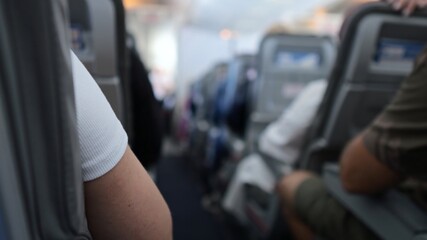 Passenger arm resting on airplane seat during flight