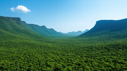 Obraz premium Breathtaking mountain range against a clear blue sky with few fluffy clouds floating above the peaks