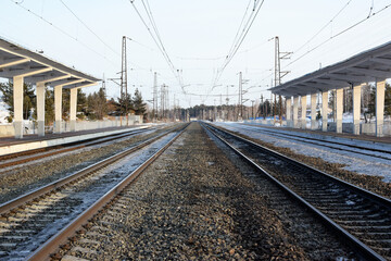 Empty railway track and empty passenger platform. Railway tracks stretch into the distance