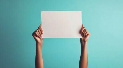 Blank protest sign held high against teal backdrop