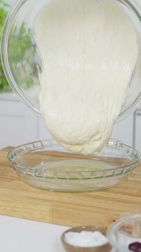 Pasando la masa de un bol a un molde de vidrio para hornear. Reposter&iacute;a, panader&iacute;a, cocina, gastronom&iacute;a, comida casera, lifestyle.